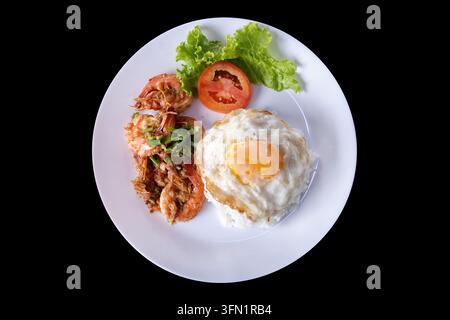 Top-Down-Ansicht eines beliebten thailändischen Comfort-Food-Gerichts mit saftigen gebratenen Garnelen mit Knoblauch und Pfeffer, serviert über gedämpftem Jasminreis, toppe Stockfoto