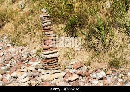 Hohe Steinpyramide, die auf einem Kiesstrand balanciert Stockfoto