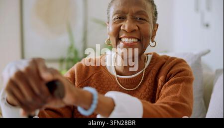 Porträt, Gehstock und Seniorin im Zuhause für Wellness, Unterstützung und Hilfe für das Gleichgewicht. Glücklich, Ruhestand und ältere afrikanische Person mit Stock für Stockfoto
