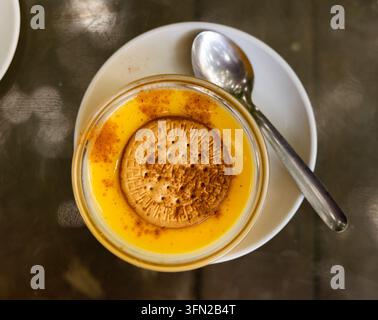 Delikates Puddingdessert aus Milch, Eiern und Zucker, verziert mit Soda-Biskuit. Stockfoto