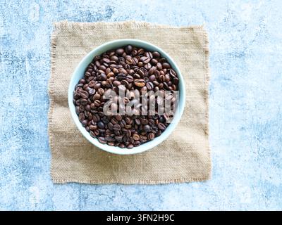 Kaffeebohnen in einer Schale auf Sackleinen Stockfoto