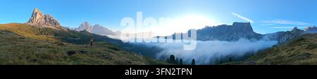 Ein ruhiger Morgen entfaltet sich, während die Sonne über den atemberaubenden Dolomiten am Passo Giau in Italien aufgeht. Die Landschaft zeigt majestätische Berge und nebligen Stockfoto