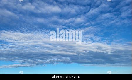 Zarte, fädige Zirruswolken über einem tiefblauen Himmel in der Schweiz Stockfoto