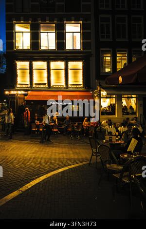 Abendgäste und ein Kellner vor dem Café Pieper und einer benachbarten Restaurantterrasse in Amsterdam, Niederlande Stockfoto