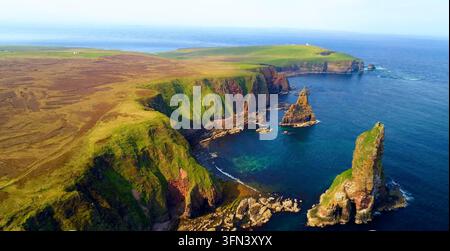 Luftaufnahme der Duncansby Stacks mit schroffen Klippen und grüner grasbewachsener Landschaft John o' Groats, Highland Council, Vereinigtes Königreich. Stockfoto