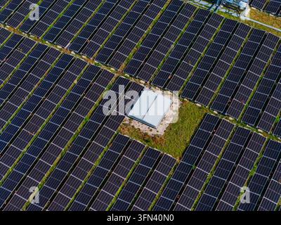 Luftaufnahme des Solarpanel-Feldes am Logistikzentrum Allhaming mit Reihen von Photovoltaik-Paneln und einem kleinen zentralen Gebäude in Allhaming, Oberoste Stockfoto