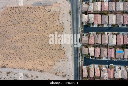 Luftaufnahme der Grenze zwischen aridem Wüstengelände und einem vorstädtischen Wohngebiet mit Häusern und asphaltierten Straßen in Las Vegas, Nevada, Un Stockfoto