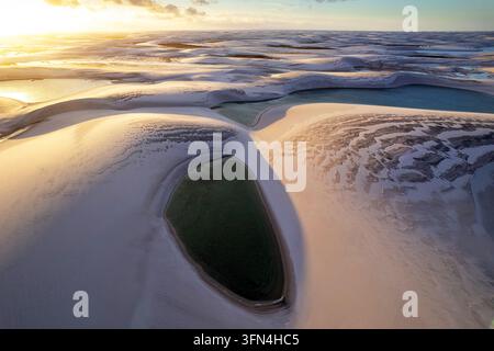 Ein atemberaubender Luftbild-Drohnenblick auf unberührte türkisfarbene Regenwasserlagunen, die sich zwischen riesigen weißen Sanddünen in Lencois Maranhenses, Brasilien, befinden. Stockfoto