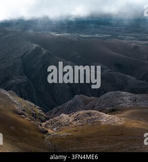 Blick auf schroffe Berghänge und tiefe Täler unter einem dramatischen bewölkten Himmel in der Sierra de La Ventana, Sierra de La Ventana, Provinz Buenos Aires Stockfoto