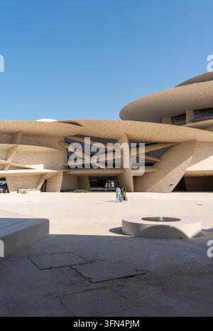 Doha, Katar - 14. Februar 2026: Ein vertikaler, sonnenbeschienener Platz des Nationalmuseums von Katar in Doha, Katar, mit zwei weiblichen Besuchern. Stockfoto