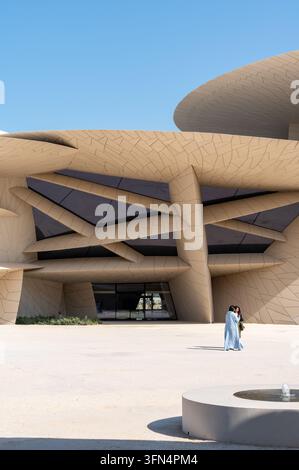 Doha, Katar - 14. Februar 2026: Vertikale Aufnahme des Nationalmuseums von Katar in Doha, Katar, mit zwei weiblichen Besuchern. Stockfoto