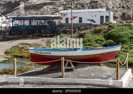 Ein traditionelles Holzfischboot ruht auf der Ausstellung neben grüner Schluchtvegetation. Los Molinos, Fuerteventura Stockfoto