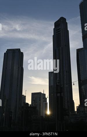 Eine dramatische Stadtsilhouette wird von hoch aufragenden Gebäuden eingerahmt, die sich gegen einen bewölkten Himmel abheben. Die niedrige Blickwinkelperspektive betont die Dimension des Architekten Stockfoto