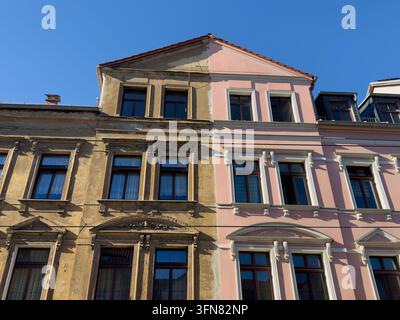 Fassade eines Wohnhauses zeigt Bereiche mit neuem und altem Putz an der Außenwand. Die kontrastierenden Oberflächen verraten verschiedene Stadien der Renovierung Stockfoto