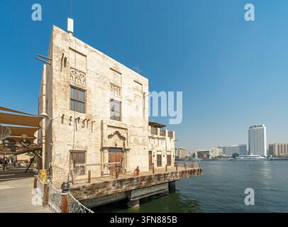 Traditionelles arabisches Gebäude auf hölzernem Steg entlang des Dubai Creek im historischen Viertel Al Seef, Dubai, Vereinigte Arabische Emirate Stockfoto