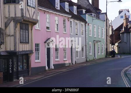 Pastellfarbene Häuser mit Schiebefenstern und ein Fachwerk-Buchladen in einer kurvenreichen Straße in Lewes, England. Stockfoto