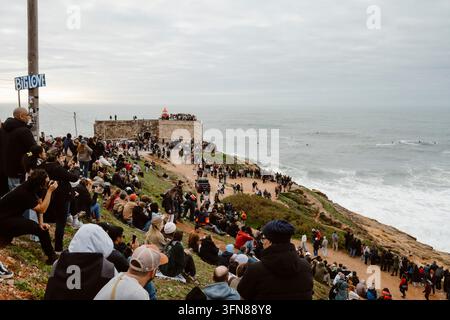 Nazare, Portugal - 6. Dezember 2025: Eine Menschenmenge beobachtet Surfer, die die Wellen bezwingen Stockfoto