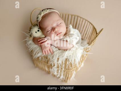 Neugeborenes Mädchen schläft friedlich in einem geflochtenen Korb. Stockfoto