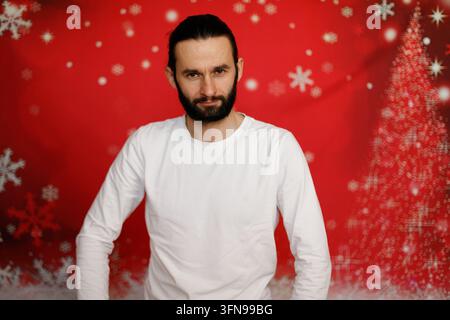 Ernsthafter Mann blickt auf Weihnachts Hintergrund in die Kamera Stockfoto