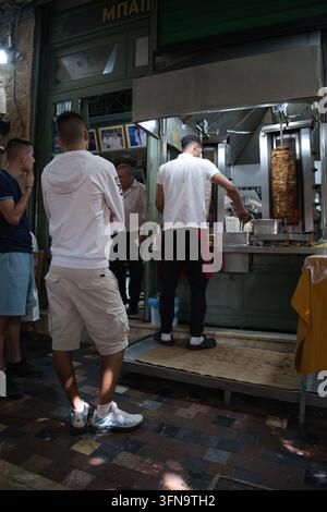 Kunden, die in Athen, Griechenland, im Sommer auf ihren traditionellen griechischen Kebab warten Stockfoto