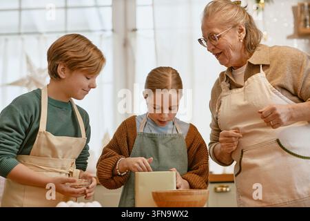 Seniorin backt mit Enkelkindern in der Küche Stockfoto
