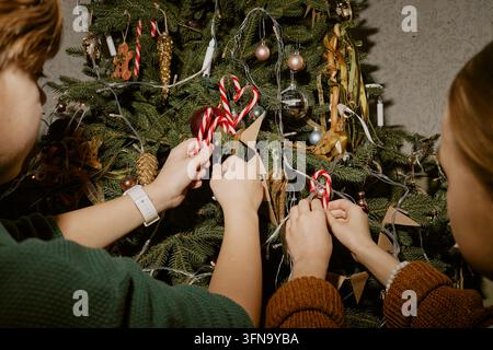 Kinder schmücken den Weihnachtsbaum zu Hause Stockfoto