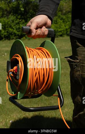 Langes orangefarbenes elektrisches Verlängerungskabel Stockfoto