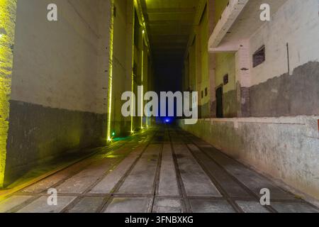 Beleuchteter Betonkorridor mit Boden-Schienen im 816 Nuklear-Militäranlagen, einer stillgelegten unterirdischen Nukleareinrichtung in Fuling, Chongqi Stockfoto