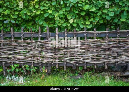 Rustischer Weidenzaun aus Stöcken im Hof im alpinen Dorf, Österreich, Nahaufnahme Stockfoto