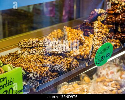 Traditionelle italienische Croccante-Nuss-Bröckchen aus karamellisierten Haselnüssen und Mandeln, ausgestellt in einem Süßwarenladen in Venedig, Italien Stockfoto