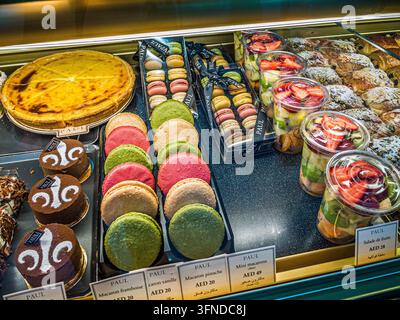 Farbenfrohe französische Macarons, Schokoladentorten, Obstsalate und Gebäck ausgestellt bei PAUL Bakery in Dubai, Vereinigte Arabische Emirate Stockfoto