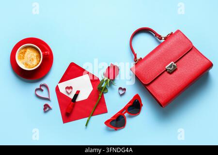 Komposition mit Tasche, Umschlag, Tasse Kaffee und Papierherzen auf blauem Hintergrund. Valentinstagsfeier Stockfoto