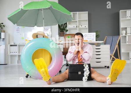Urlaubsplanung und Work-Life-Balance, begeisterter Geschäftsmann mit Aktentasche und Flossen, der im Büro von den Sommerferien träumt Stockfoto