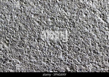 Raue, grau gestrichene Oberfläche aus Gusseisen. Makro-Hintergrund aus silbernem Eisenmaterial mit höckeriger, körniger Industriebeschichtung. Nahaufnahme von strukturellen Details Stockfoto