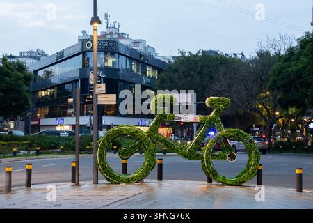 Mexiko-Stadt, Mexiko - 25. August 2026: Große grüne Topfpflanze-Fahrradskulptur auf dem Fußgängerweg an einer Ecke vor einem modernen Bürogebäude in Stockfoto