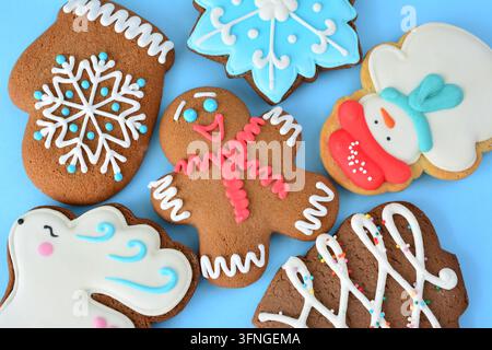 Weihnachtslebkuchen und Feiertagsnaschereien auf blauem Hintergrund, Flat Lay Stockfoto
