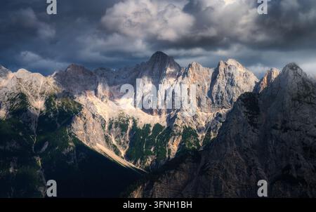 Gebirgszug mit felsigen Gipfeln unter stürmischem Himmel bei Sonnenuntergang Stockfoto