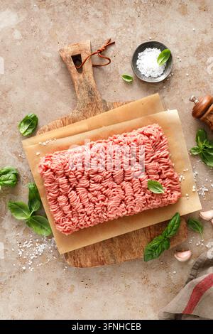 Hackfleisch rohes gemahlenes Schwein und Rind auf Holzbrett mit Zutaten Stockfoto