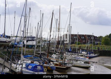 Yachtmasten drängen sich im Creek, mit Häusern dahinter, in Rye, England. Stockfoto