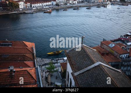 Erhöhte Ansicht von Porto, Portugal, mit Terrazzendächern, Booten auf dem Douro und historischen Ufergebäuden entlang der malerischen Uferpromenade Stockfoto