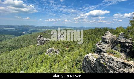 Ein weitläufiger Blick über die Landschaft des Elbsandsteingebirges in Sachsen, Deutschland, zeigt schroffe Felsformationen, bewaldete Hänge, tiefe Täler und weitläufige Naturlandschaften. Die markante Landschaft der Sächsischen Schweiz schafft eine dramatische und doch friedliche Umgebung Stockfoto