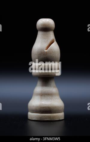 Weißer hölzerner Schachläufer auf dunklem Hintergrund Stockfoto