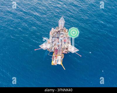 Luftaufnahme einer großen Offshore-Ölplattform, die im offenen Meer operiert, zeigt industrielle Energieinfrastruktur, Bohrausrüstung und marine Ölex Stockfoto