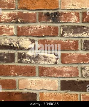 Hintergrund mit der Textur einer alten Ziegelwand, neu gestrichen. Abstrakter Vintage-Hintergrund. Farbige Ziegelwand, mehrfarbige Mauerarbeit. Stockfoto