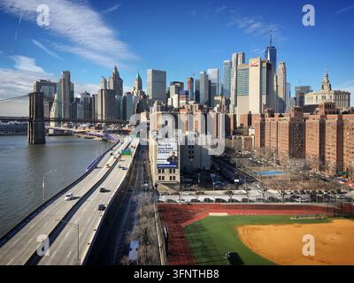 Blick auf New York City mit der Brooklyn Bridge links, die den East River überspannt. Die Skyline zeigt ikonische Wolkenkratzer, darunter One World Trade Stockfoto