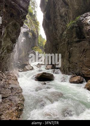 Ein starker Fluss stürzt durch eine enge Schlucht über Felsen und erzeugt weißes Wasser in Garmisch-Partenkirchen, Bayern, Deutschland. Steil, turmhoch Stockfoto