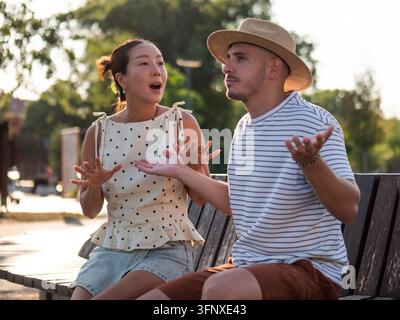 Mann und Frau besprechen Beziehungsprobleme mit ausdrucksstarken Handgesten im Freien. Stockfoto
