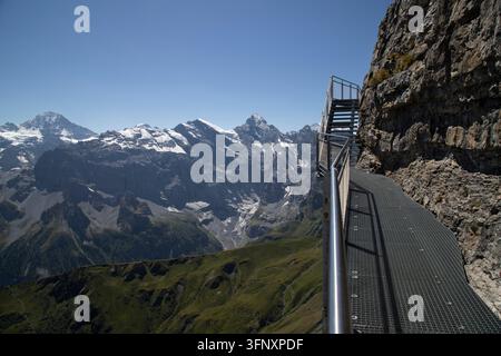 Metallsteg, der an einer Klippenwand mit Panoramablick auf die Berge in der Schweiz gebaut wurde Stockfoto