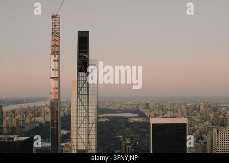 111 West 57th Street Turm im Bau mit rotem Kran über dem Central Park in der Dämmerung Stockfoto