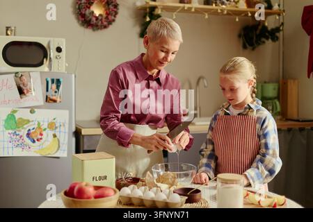 Seniorin und Mädchen backen zusammen in der Küche für Weihnachten Stockfoto